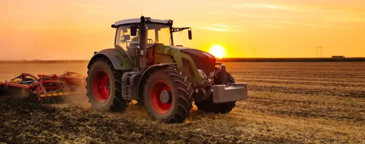 Tractor in a field at sunset